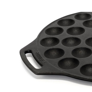 Ronde gietijzeren Petromax poffertjespan met een vlakke bodem en twee handgrepen voor het bakken van 30 poffertjes op open vuur.