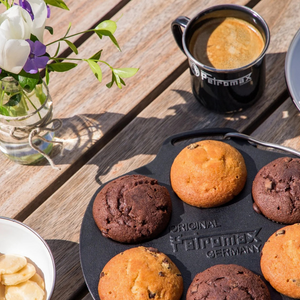 Gietijzeren Petromax mf6 muffinvorm met 6 inkepingen en een metalen draagbeugel voor het bakken van muffins boven open vuur.