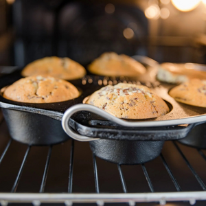 Gietijzeren Petromax mf6 muffinvorm met 6 inkepingen en een metalen draagbeugel voor het bakken van muffins boven open vuur.