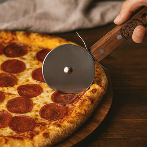 Petromax RVS pizzasnijder in de vorm van een wiegemes met een houten handgreep voor het moeiteloos snijden van pizza's en plaatkoek.