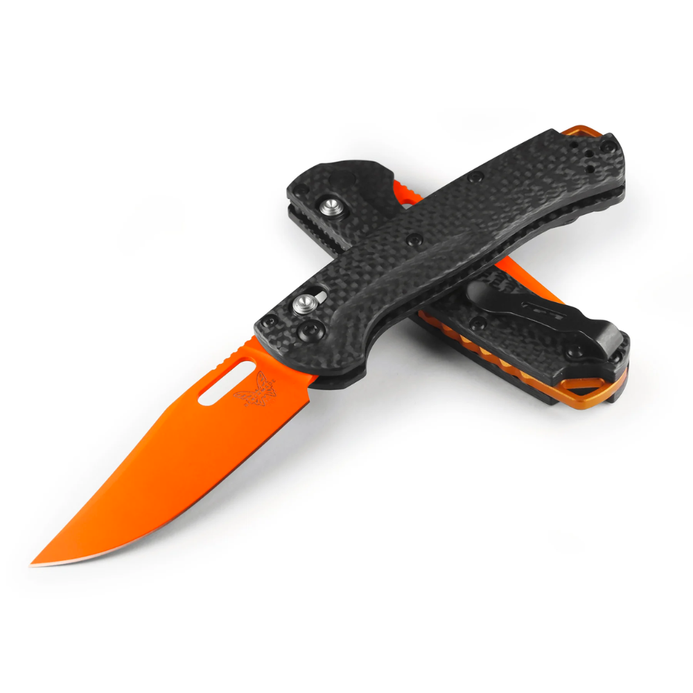 Benchmade Taggedout zakmes met feloranje lemmet en carbonfiber handgreep deels ingeklapt op een witte achtergrond