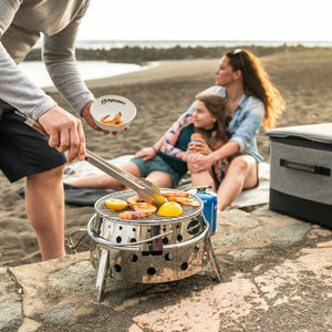 Petromax RVS barbecuetang klein model met een houten handgreep, golvende kop en sluitmechanisme voor outdoor grillen.