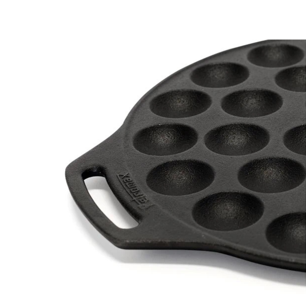 Ronde gietijzeren Petromax poffertjespan met een vlakke bodem en twee handgrepen voor het bakken van 30 poffertjes op open vuur.