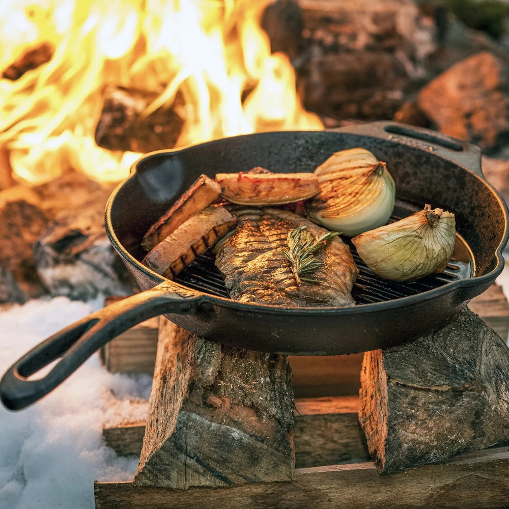 Gietijzeren Petromax grill skillet van 35 cm met een geribbelde bodem voor grillstrepen en handige schenktuiten aan de zijkanten.