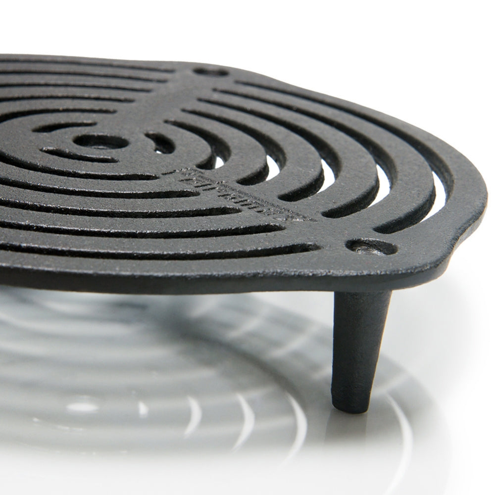 Ronde gietijzeren Petromax onderzetter van 23 cm met pootjes en een opengewerkt patroon voor het stabiel neerzetten van hete Dutch Ovens.