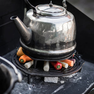 Ronde gietijzeren Petromax onderzetter van 23 cm met pootjes en een opengewerkt patroon voor het stabiel neerzetten van hete Dutch Ovens.