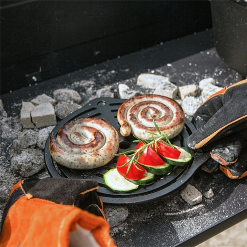 Ronde gietijzeren Petromax onderzetter van 23 cm met pootjes en een opengewerkt patroon voor het stabiel neerzetten van hete Dutch Ovens.
