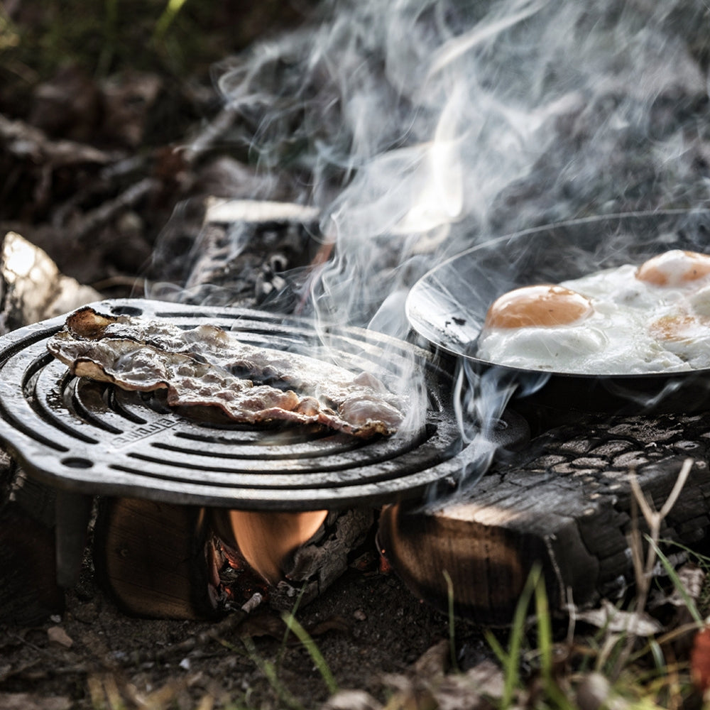 Ronde gietijzeren Petromax onderzetter van 23 cm met pootjes en een opengewerkt patroon voor het stabiel neerzetten van hete Dutch Ovens.